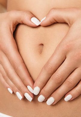 Pregnancy or diet concept, female hands forming heart shape on the stomach